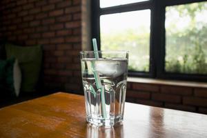glas mineraalwater op houten tafel in restaurant foto