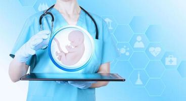 icoon van een embryo met een beschermend handgebaar van een arts-gynaecoloog als symbool van conceptie en in-vitrofertilisatie. blauwe medische achtergrond met thema-pictogrammen. poster. foto