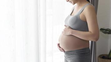 jonge mooie zwangere vrouw thuis, kraam- en zwangerschapszorgconcept foto