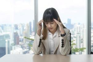 jonge zakenvrouw gestrest en moe in modern kantoor foto
