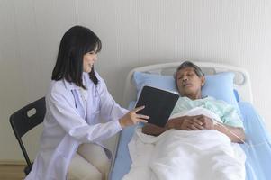 aziatische senior mannelijke patiënt raadpleegt en bezoekt arts in het ziekenhuis.. foto