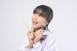 jonge vrouwelijke tandarts glimlachend over witte achtergrond studio foto