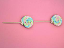 kleurrijke regenboog kleur meringue lolly snoep op roze achtergrond. schattig zomer zoet dessert concept. foto