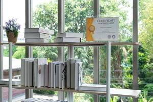 certificaat van prestatie op de boekenplank in de moderne bibliotheek foto