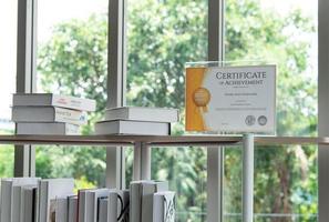 certificaat van prestatie op de boekenplank in de moderne bibliotheek foto