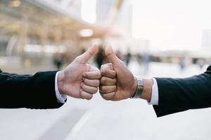 zakenman in pak handdruk samen voor succesvol in de stad en wandelende mensen achtergrond. foto