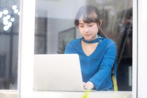 mooi portret azië jonge vrouw die online werkt op laptop zittend in café winkel, professionele vrouwelijke freelance met behulp van notebookcomputer, bedrijfs- en communicatieconcept. foto