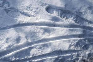 bandensporen op besneeuwde straten in een close-up weergave. foto