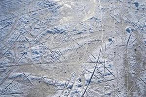 uitzicht op een bevroren meer in de winter met veel schaatsbanen. foto