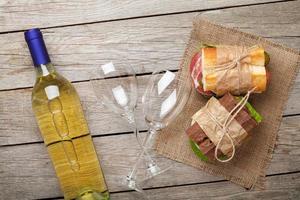 twee sandwiches en witte wijn foto