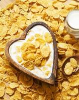 gezond ontbijt: cornflakes met melk in een houten kom foto
