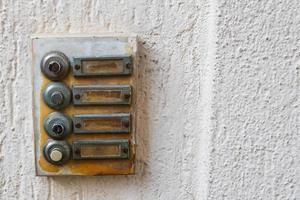 close-up van een oude metalen plaat op een huis met bellen foto