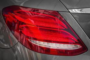 macro weergave van moderne grijze auto xenon lamp achterlicht, bumper, kofferbak deksel. buitenkant van een moderne auto foto