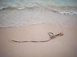 touw op het zandstrand met de zeegolf foto