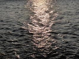 reflecties van de zon in de zee foto