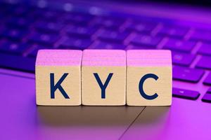 kyc woord op houten blokken op laptop met kleurrijke verlichting. online ken uw klantconcept foto