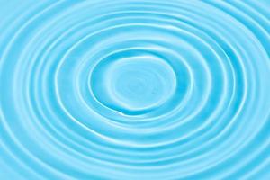 blauwe water achtergrondstructuur met druppel cirkels op het wateroppervlak foto