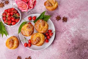 verse heerlijke rijstmeelmuffins met kersen op een betonnen ondergrond. zelfgemaakte gebakjes foto