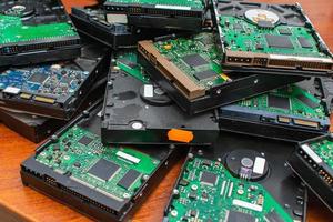 een stapel stoffige kapotte en verouderde harde schijven voor verwijdering en recycling. elektronisch datawarehouse foto