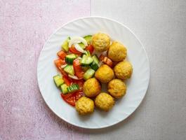 smakelijke kipballetjes met komkommer en tomatensalade. foto