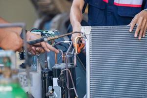 reparatieteam voor airconditioning gebruikt brandstofgassen en zuurstof om metalen te lassen of te snijden, autogeen lassen en autogeen snijprocessen, reparateur op de vloer die airconditioningsysteem bevestigt foto