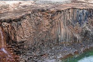 schilderachtig uitzicht op de vorming van basaltkolommen door de litlanesfoss-waterval in de vallei foto