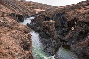 stroom stroomt te midden van basaltkolommen rotsformatie bij oostfjorden tegen lucht foto