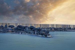 stenen bij geothermische spa in blauwe lagune tegen bewolkte hemel tijdens zonsondergang foto