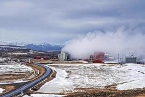 stomende koeltoren bij de geothermische elektriciteitscentrale van Krafla over de weg tegen de lucht foto