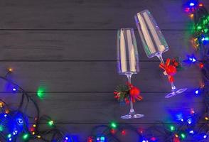 nieuwjaarsachtergrond met twee champagneglazen en kerstverlichting