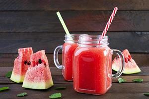 verse heerlijke watermeloen smoothie met ijs op houten achtergrond foto