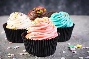 smakelijke kleurrijke cupcakes geïsoleerd op een grijze achtergrond. heerlijke cupcake foto