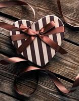 hartvormige Valentijnsdag geschenkdoos op houten platen. foto