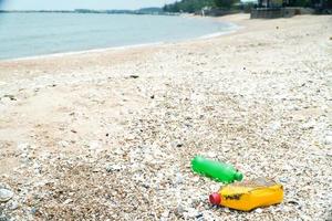 vervuiling van strandvuil, plastic flessen en ander afval op het strand. foto