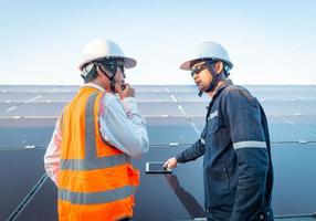 ingenieurs met investeerders lopen om de werking van het zonnepark te controleren, zonnepaneelsystemen, alternatieve energie om de wereld te behouden is energie, fotovoltaïsche module-idee voor de productie van schone energie foto