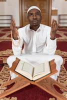 jonge Afrikaanse moslim man leest de koran