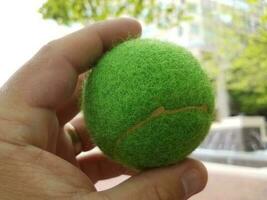 hand met een groene tennisbal foto