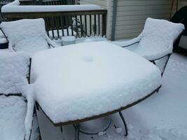 een halve meter sneeuw op tafel en stoelen foto