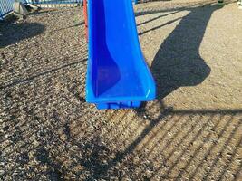 blauwe plastic glijbaan met bruine mulch of houtsnippers foto