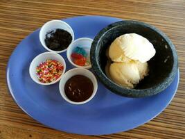 vanille-ijs met hagelslag en chocolade op blauw bord foto