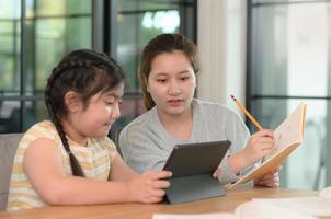 Aziatische meisjes studeren met een tutor, privélessen thuis, zussen en zussen. foto