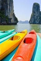 kleurrijke kajaks met de achtergrond van kalksteenbergen bij de baai van Halong, Vietnam foto