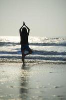 yoga vrouw op het strand foto