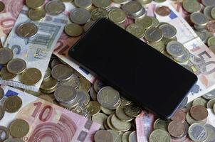 mobiel betalen en smartphone - een mobiel apparaat dat op een stapel geld ligt foto