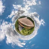 kleine planeet. bolvormig uitzicht in een veld op een mooie dag met mooie wolken foto