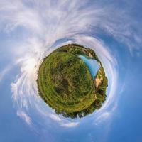 kleine planeet. bolvormig uitzicht in een veld in een mooie avond met mooie wolken foto