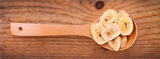 gedroogde bananenchips in houten lepel