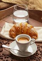 espresso met croissant en glas water foto