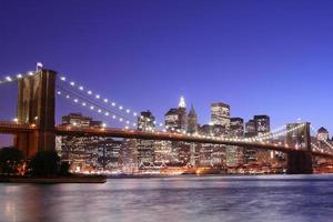 Brooklyn Bridge en Manhattan skyline in de nacht foto