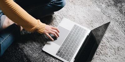 close-upbeeld van de handen van een zakenvrouw die thuis op het toetsenbord van de laptop werken en typen foto